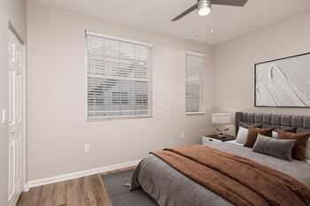 A bedroom with a bed, pillows, and a ceiling fan
